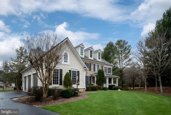 a view of a big house with a big yard and large trees