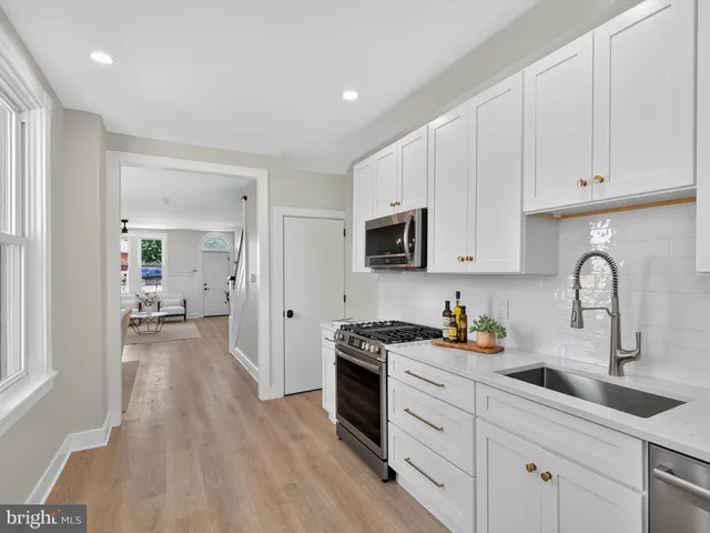 a kitchen with sink a stove and cabinets