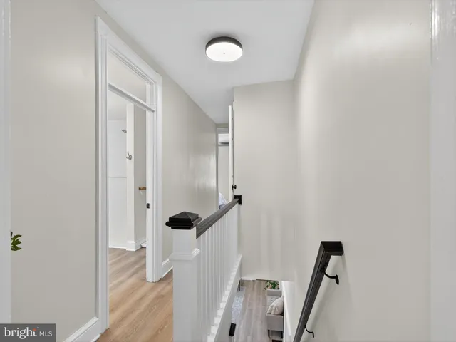 a view of a hallway with wooden floor and staircase