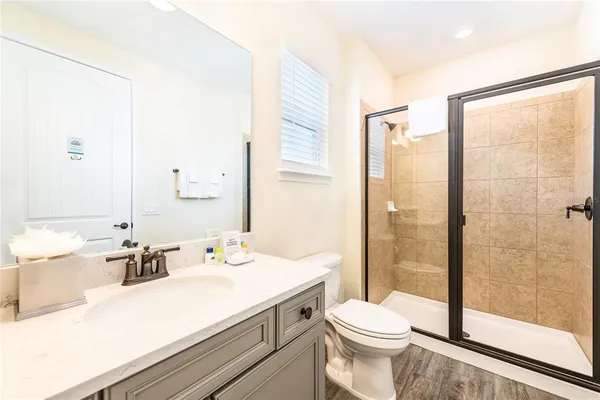 a bathroom with a sink a toilet and shower