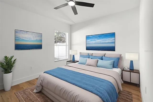 a bedroom with a large bed and a potted plant