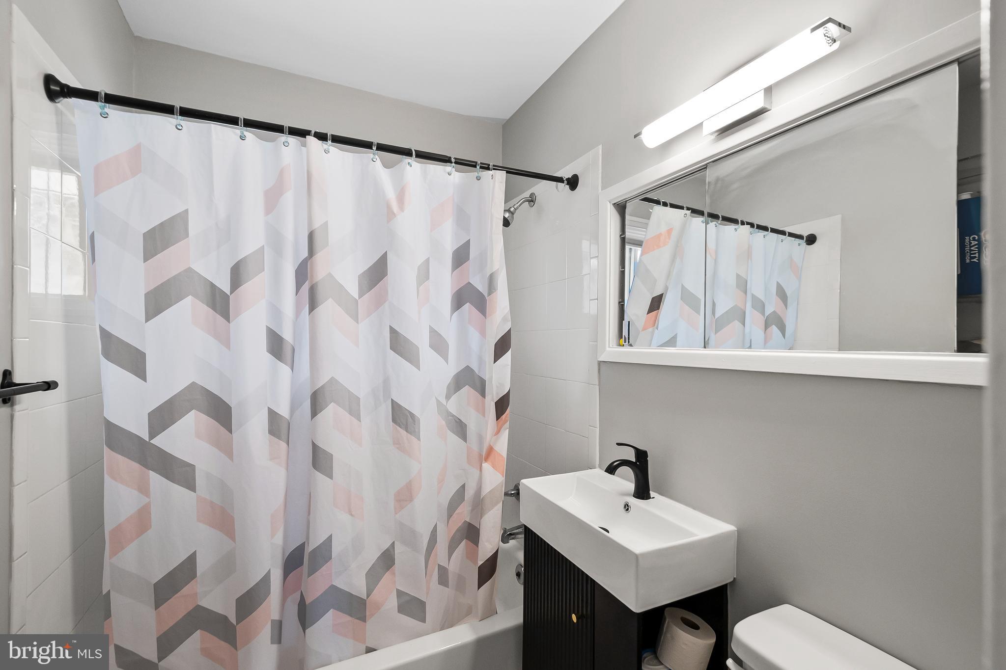 1204 Lindsay Road Oxon Hill, MD 20745 - Photo 21 of 28 a bathroom with a sink mirror and a window
