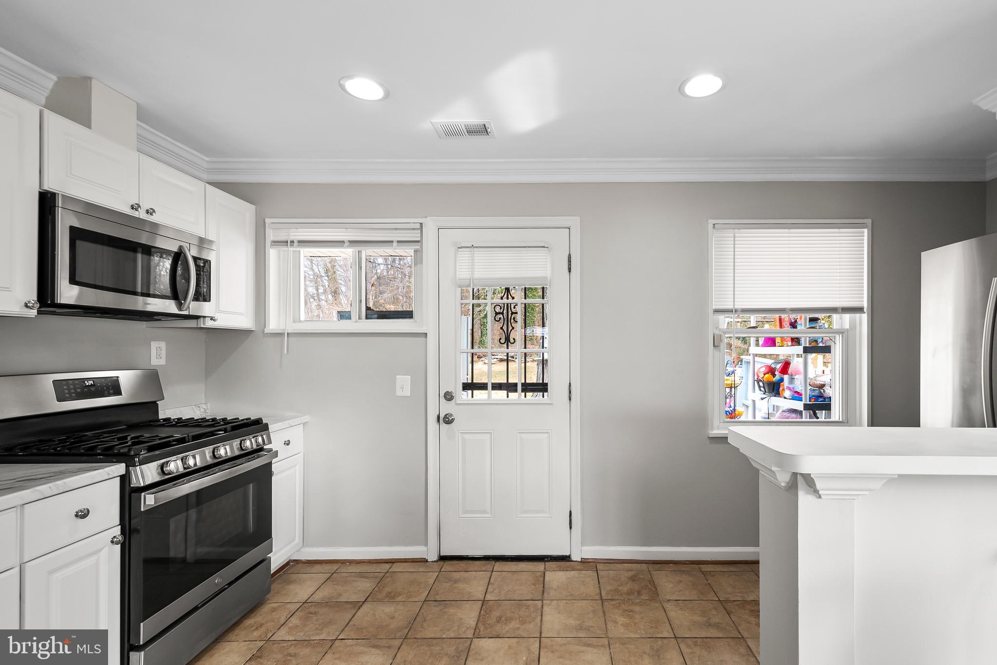 1204 Lindsay Road Oxon Hill, MD 20745 - Photo 10 of 28 a kitchen with stainless steel appliances a stove a microwave and a refrigerator