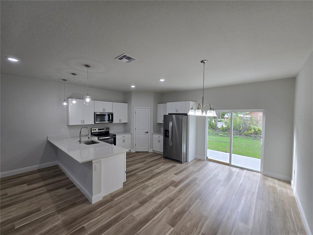 2717 Southwest 140th Loop Ocala, FL 34473 - Photo 9 of 40 a kitchen with stainless steel appliances a refrigerator and a stove top oven