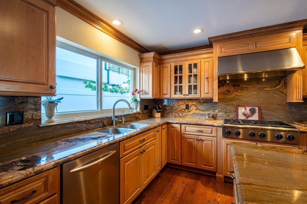 2317 Northeast 28th Court Lighthouse Point, FL 33064 - Photo 18 of 49 a kitchen with stainless steel appliances granite countertop a sink a stove and a wooden cabinets