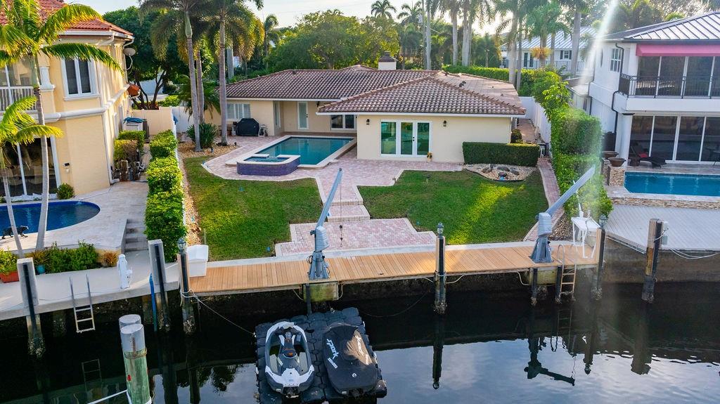 2317 Northeast 28th Court Lighthouse Point, FL 33064 - Photo 31 of 49 a patio table and chairs with potted plants and palm trees
