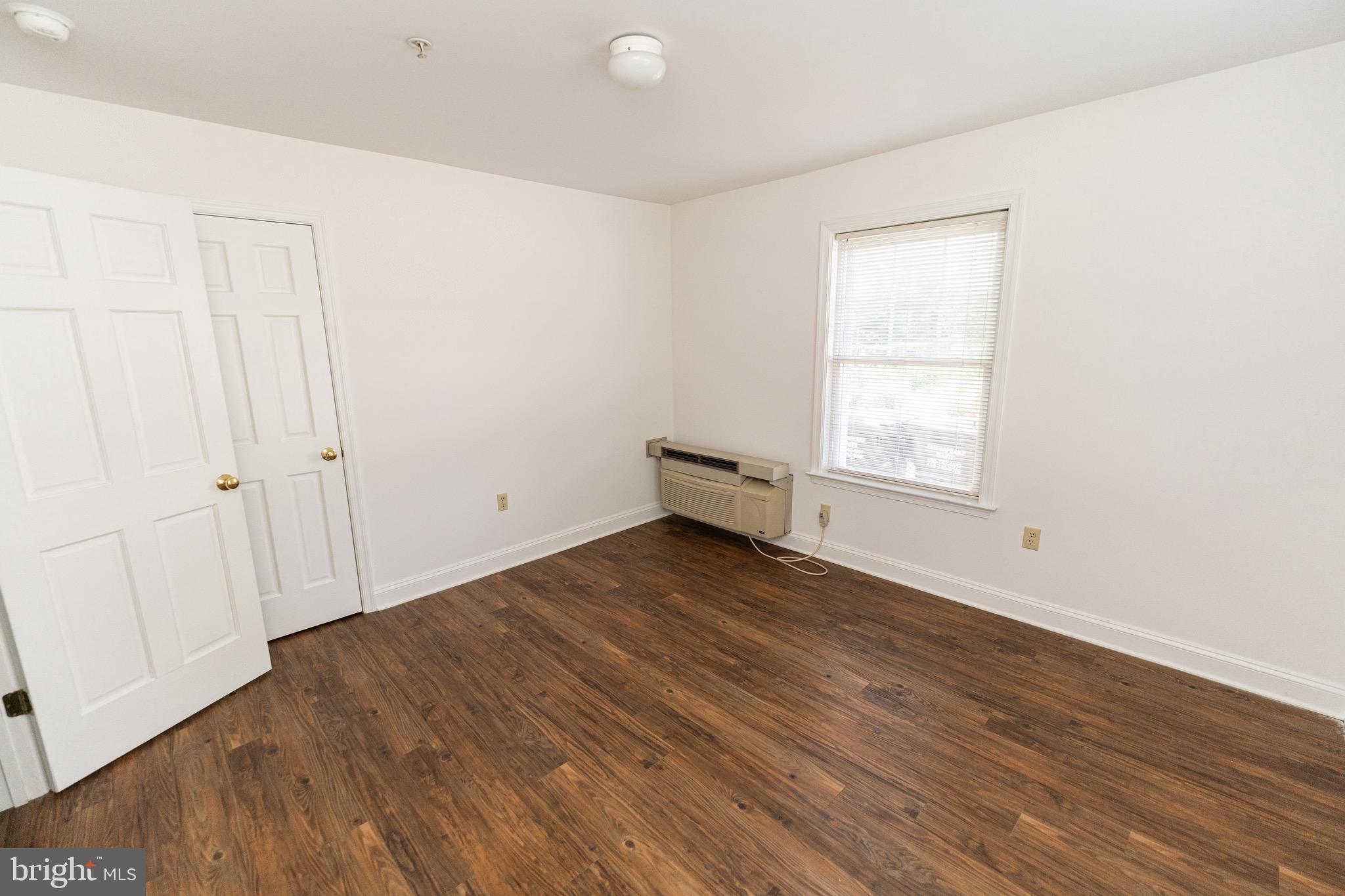 804 Travers Street, Unit 2 Cambridge, MD 21613 - Photo 23 of 26 an empty room with wooden floor and windows