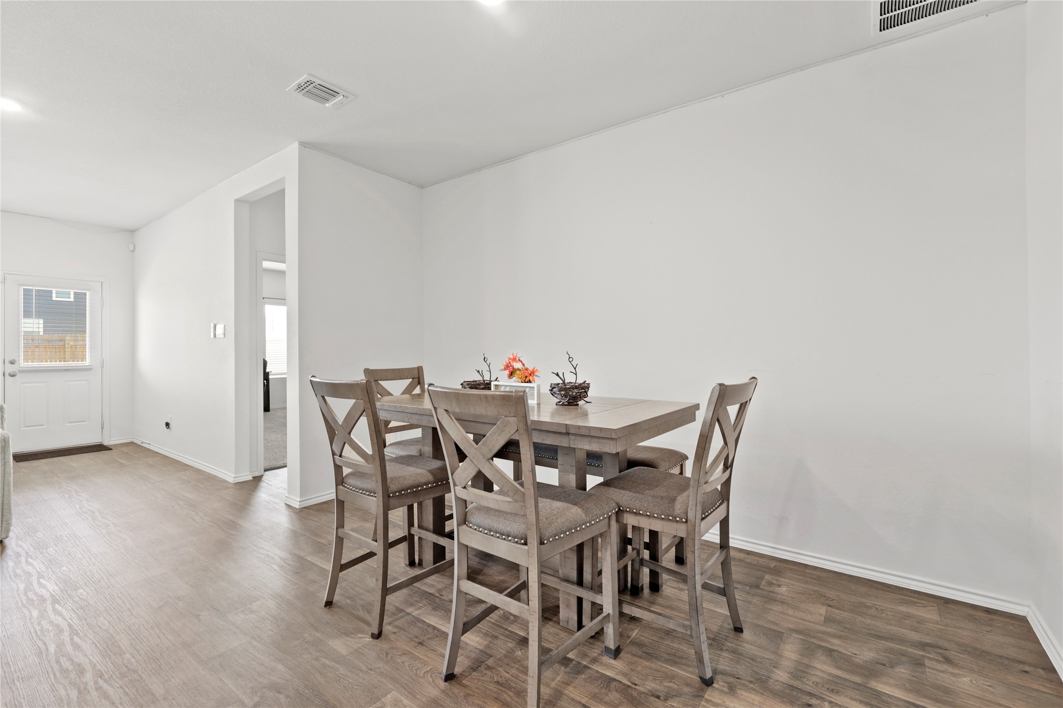 790 Arnold Loop Kyle, TX 78640 - Photo 13 of 36 Dinner with a flow! Enjoy the seamless transition from the kitchen to the dining table, featuring bright recessed lighting and beautiful wood-style flooring that makes every meal feel like a special occasion.