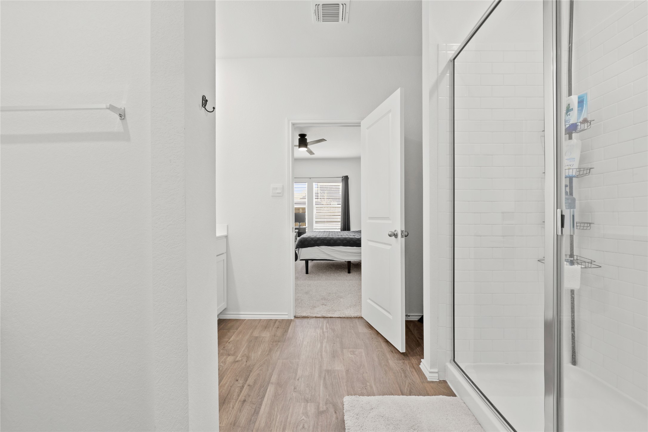 790 Arnold Loop Kyle, TX 78640 - Photo 19 of 36 Bright, clean, and modern! From the modern fixtures to the beautiful wood-style flooring, this primary bath combines high-end finishes with a spacious layout that feels fresh and inviting.