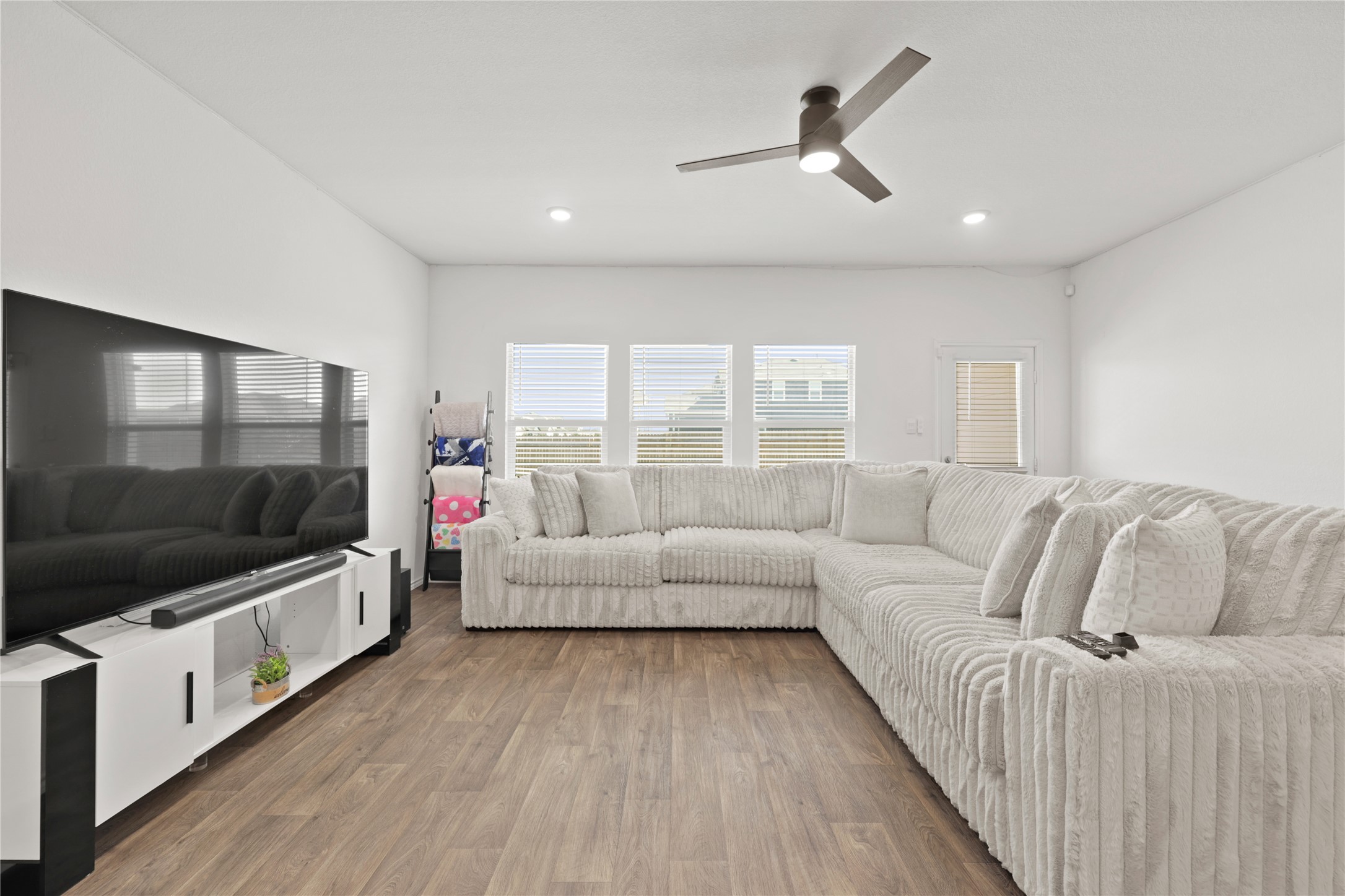 790 Arnold Loop Kyle, TX 78640 - Photo 5 of 36 Light, bright, and airy! This is the first of two spacious living areas, featuring gorgeous wood-style flooring and large windows that soak the open-concept heart of the home in Texas sunshine.