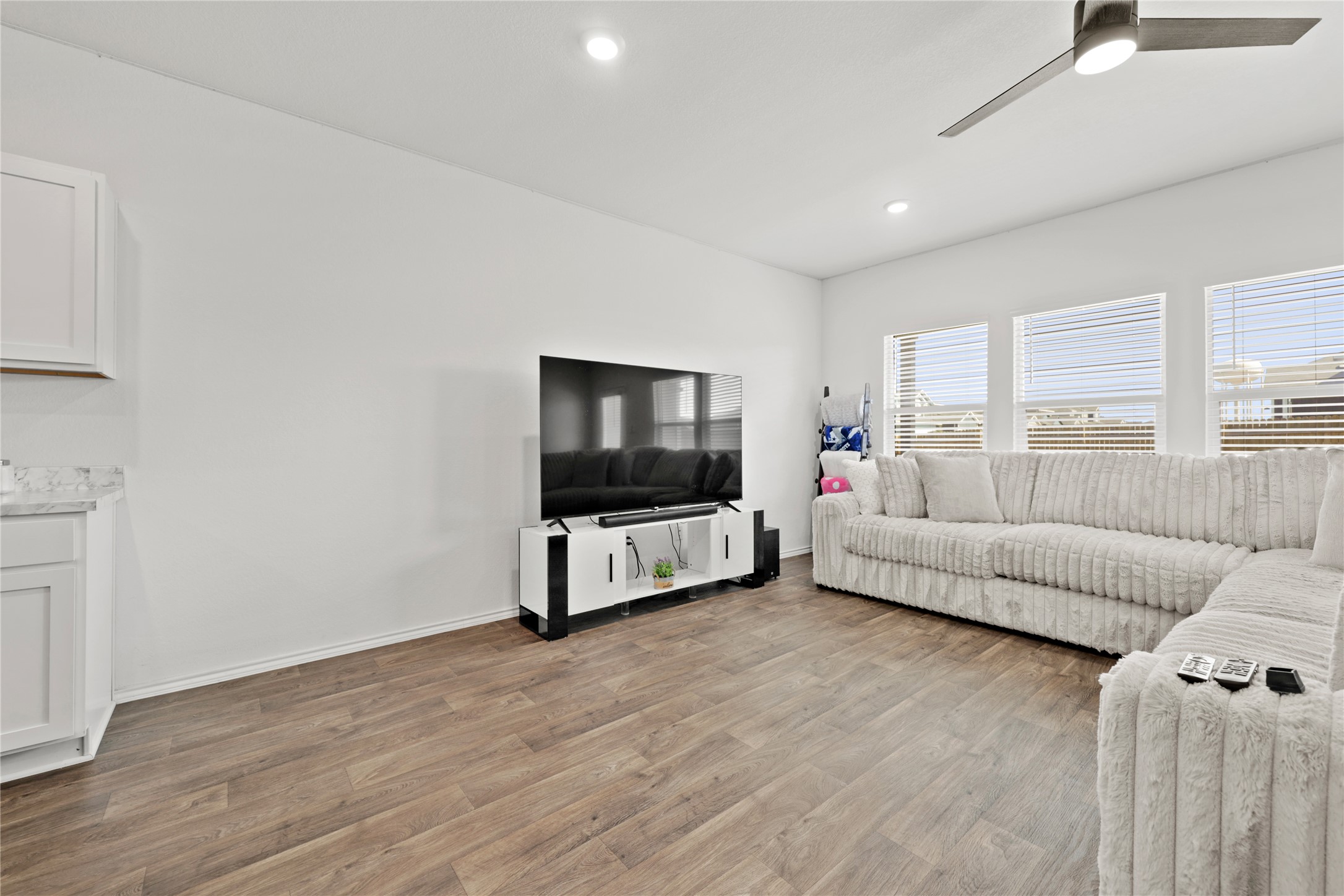790 Arnold Loop Kyle, TX 78640 - Photo 6 of 36 Designed for downtime or hosting! This expansive living area features a clean, modern palette and gorgeous wood-look flooring that ties the whole open-concept space together.