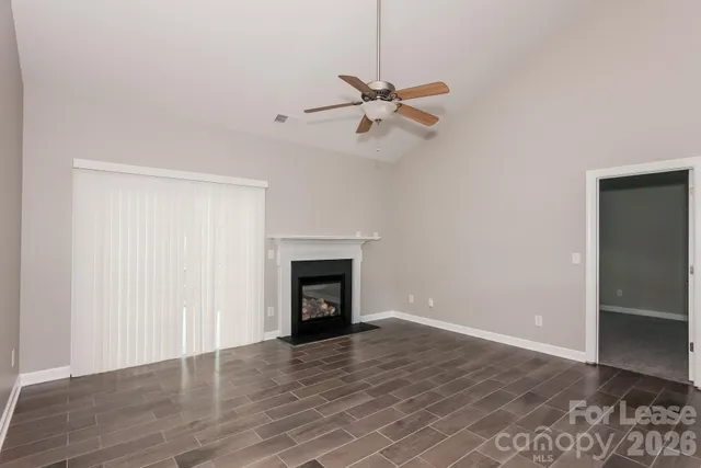 a view of empty room with wooden floor and fireplace