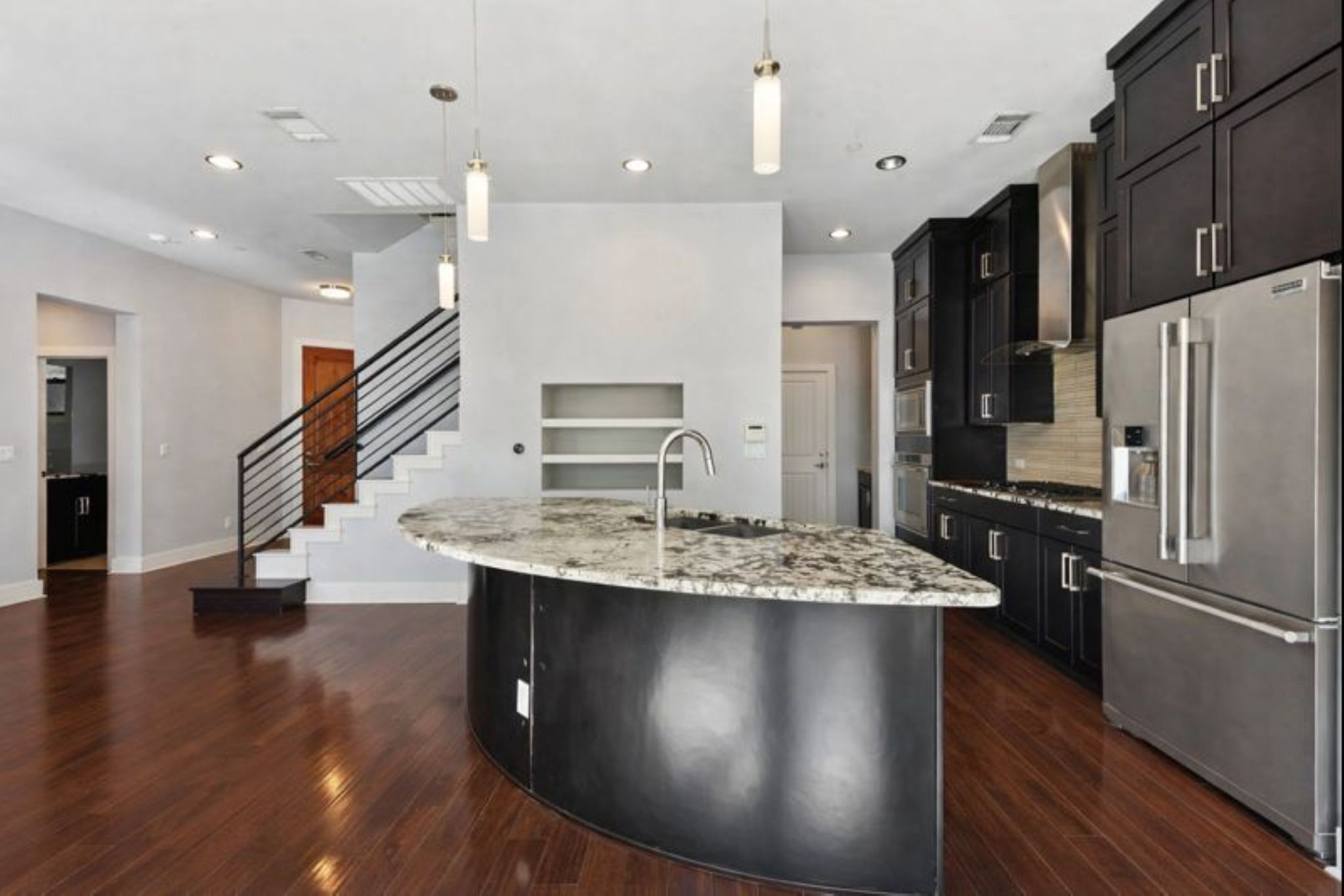 8110 Ranch Road 2222, Unit 98 Austin, TX 78730 - Photo 11 of 37 Kitchen with dark cabinetry, appliances with stainless steel finishes, decorative light fixtures, light stone counters, and recessed lighting