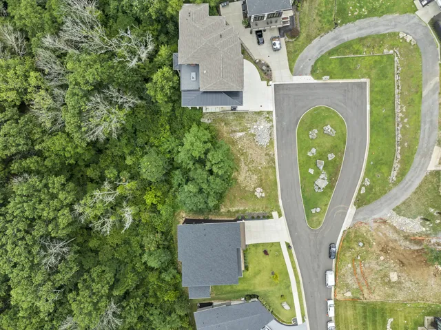 an aerial view of a house with swimming pool and a yard