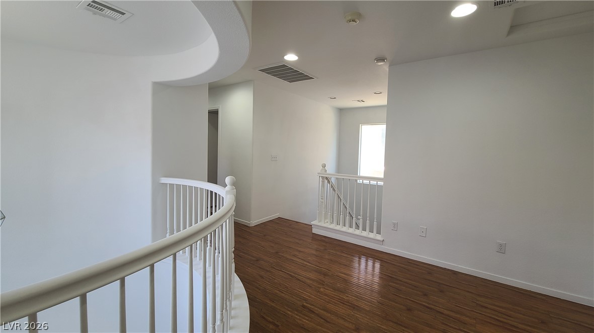 8944 Rutherford Grove Street Las Vegas, NV 89148 - Photo 14 of 35 Rich hardwood floors guide you through this inviting upper-level landing, featuring graceful curved railings.