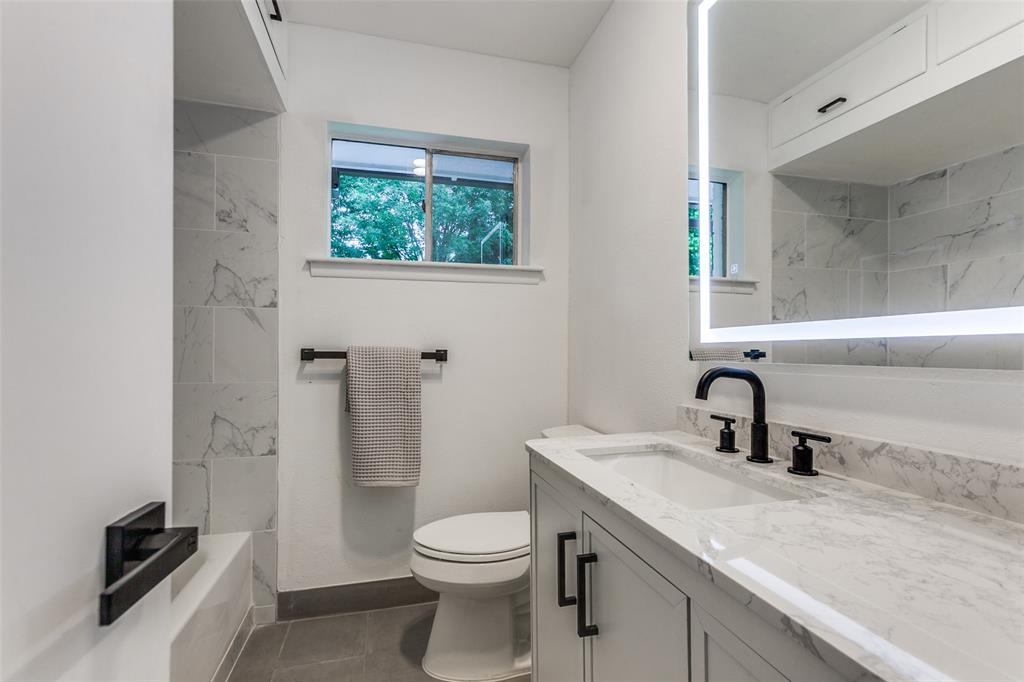 2718 Runningbrook Lane Dallas, TX 75228 - Photo 16 of 23 a bathroom with a granite countertop sink toilet and shower
