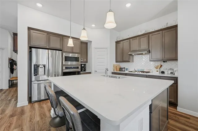 a kitchen with stainless steel appliances a refrigerator sink and microwave