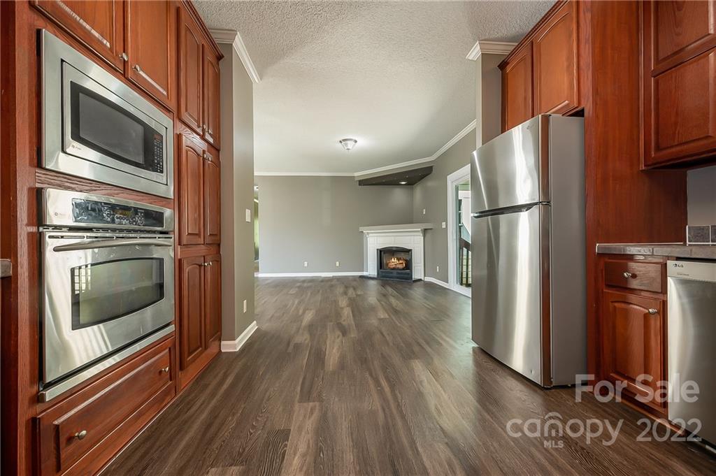 6410 Big Level Road Mill Spring, NC 28756 - Photo 11 of 32 a kitchen with granite countertop a refrigerator stove and microwave