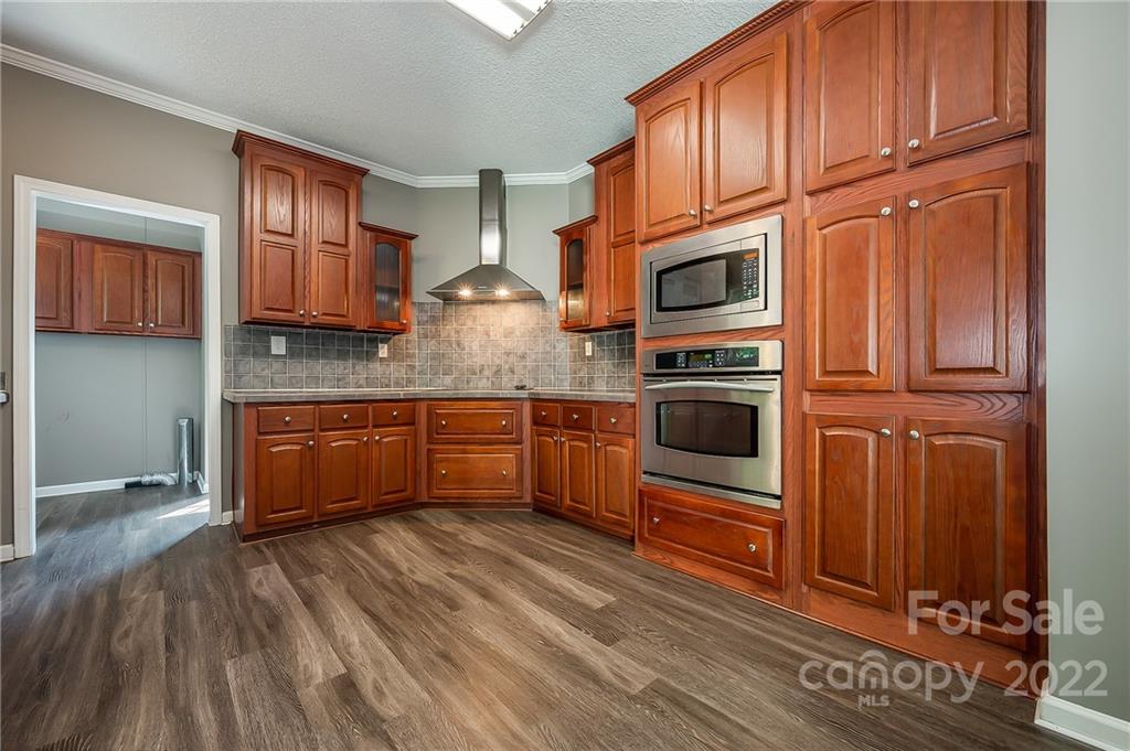 6410 Big Level Road Mill Spring, NC 28756 - Photo 12 of 32 a kitchen with stainless steel appliances granite countertop a stove a microwave and a refrigerator