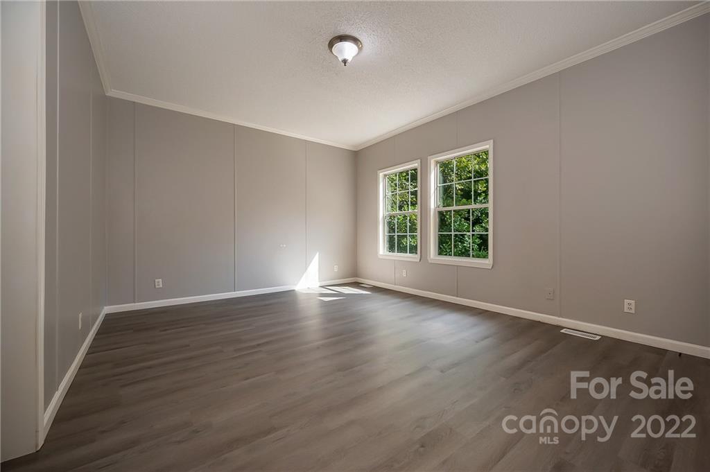 6410 Big Level Road Mill Spring, NC 28756 - Photo 20 of 32 an empty room with wooden floor and windows