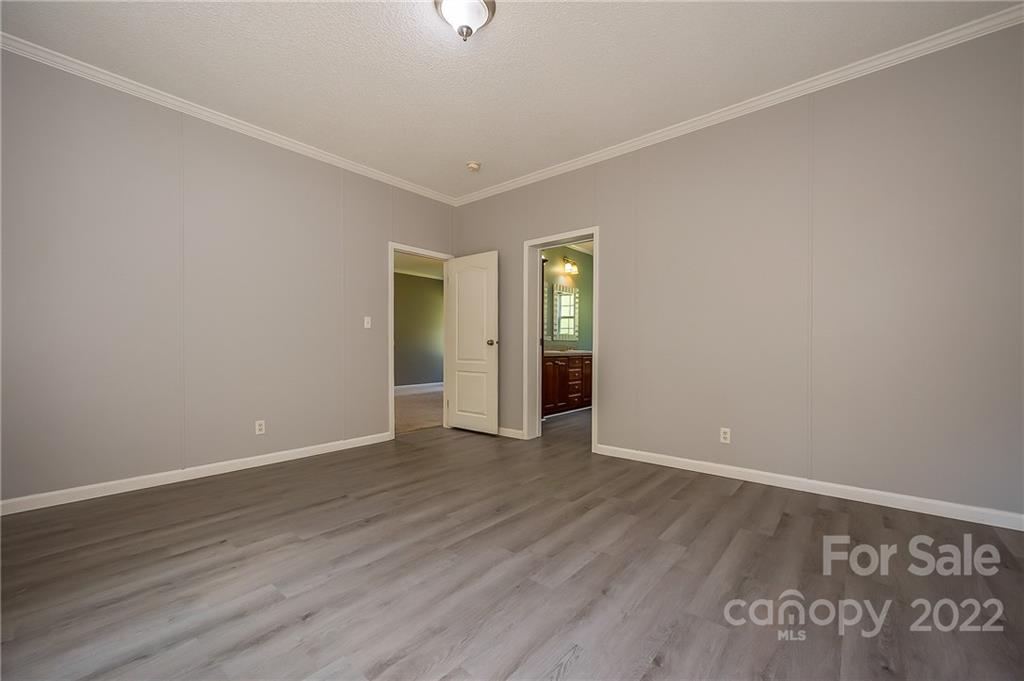 6410 Big Level Road Mill Spring, NC 28756 - Photo 21 of 32 a view of an empty room with window and wooden floor