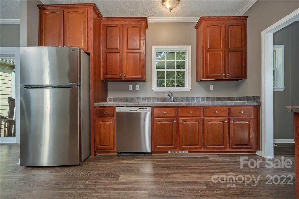 6410 Big Level Road Mill Spring, NC 28756 - Photo 10 of 32 a kitchen with granite countertop stainless steel appliances a refrigerator and a sink