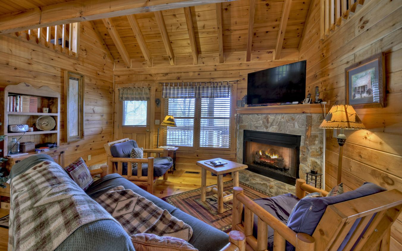 664 Laurel Ridge Road Blue Ridge, GA 30513 - Photo 6 of 36 a living room with furniture a flat screen tv and a fireplace