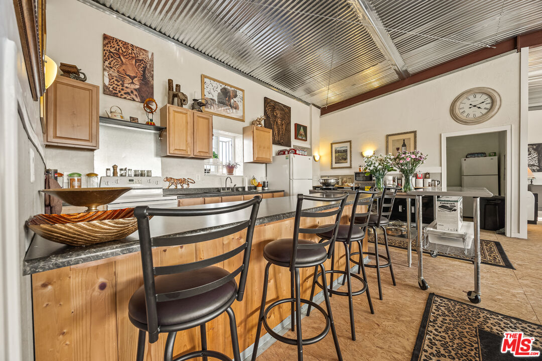 9025 Camp Rock Road Lucerne Valley, CA 92356 - Photo 25 of 54 a kitchen with stainless steel appliances granite countertop table chairs and a wooden floor