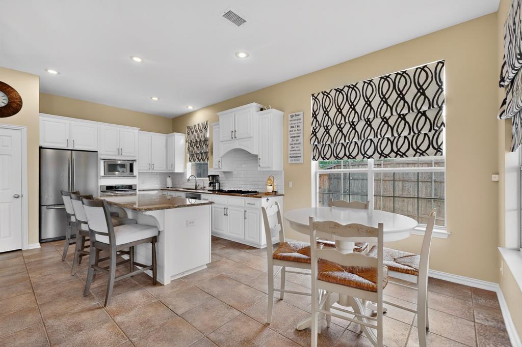 4004 White Porch Road Plano, TX 75024 - Photo 16 of 40 a kitchen with a dining table chairs and refrigerator