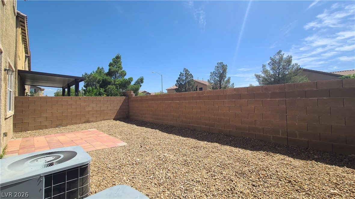 8944 Rutherford Grove Street Las Vegas, NV 89148 - Photo 33 of 35 An inviting gravel yard, fully fenced for privacy, features a spacious covered patio.