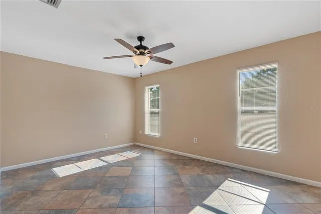 a view of a big room with wooden floor and chandelier fan