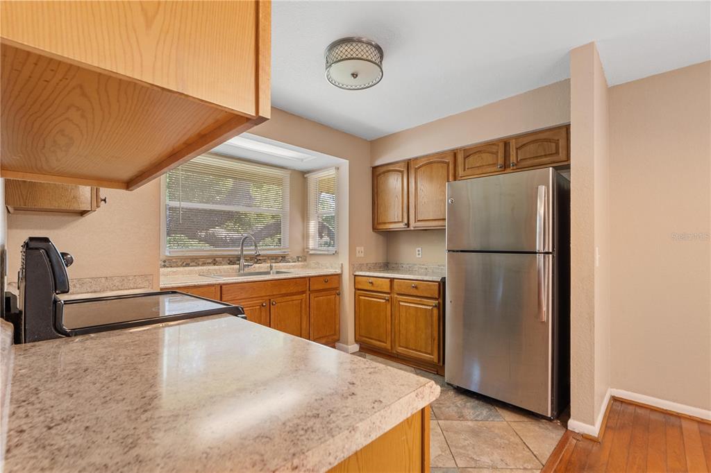 6007 Waycross Drive Spring Hill, FL 34606 - Photo 10 of 33 a kitchen with stainless steel appliances granite countertop a refrigerator a stove and a sink with wooden floor