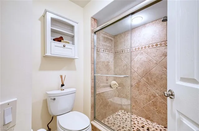 a bathroom with a toilet and a shower