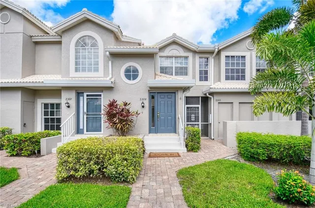 a front view of a house with garden and trees