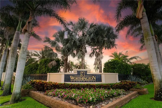 a view of sign board and tree in the background
