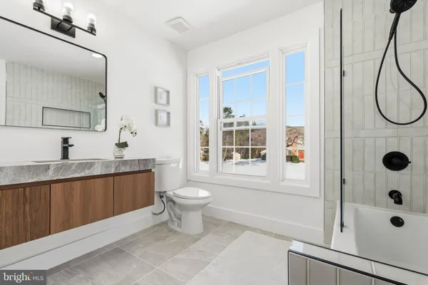 a bathroom with a sink a toilet a mirror and shower