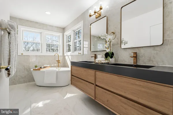 a bathroom with a bathtub sink and mirror