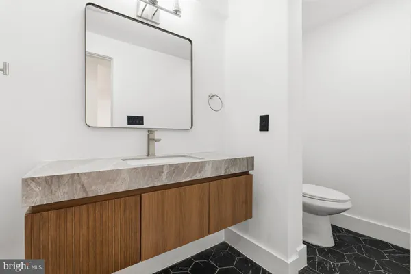 a bathroom with a sink a toilet and mirror