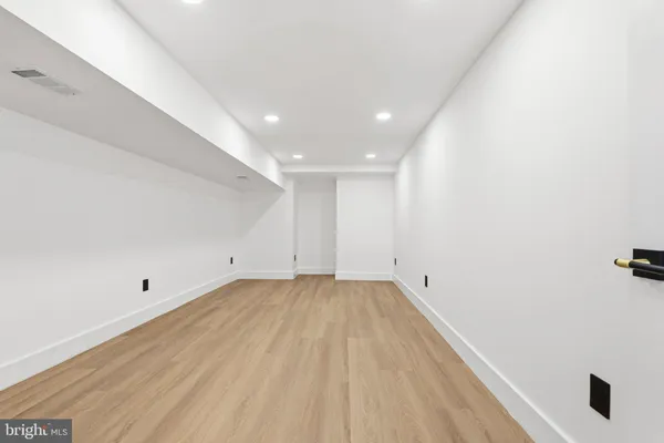 a view of empty room with wooden floor