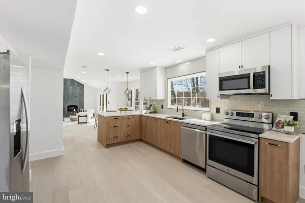 a large kitchen with stainless steel appliances granite countertop a stove a sink and a refrigerator