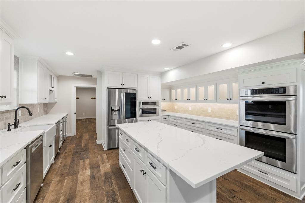 1845 Summer Lane Keller, TX 76262 - Photo 8 of 28 a kitchen with stainless steel appliances a stove top oven a sink a refrigerator white cabinets and wooden floor