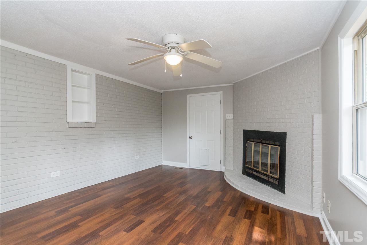 600 North King Charles Road Raleigh, NC 27610 - Photo 13 of 24 Door to back porch and wood burning fireplace. Fresh paint and durable laminate flooring.