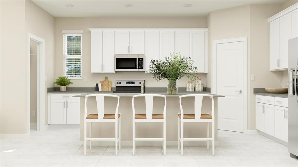 3261 Zuni Road St. Cloud, FL 34771 - Photo 2 of 21 a kitchen with white cabinets and stainless steel appliances