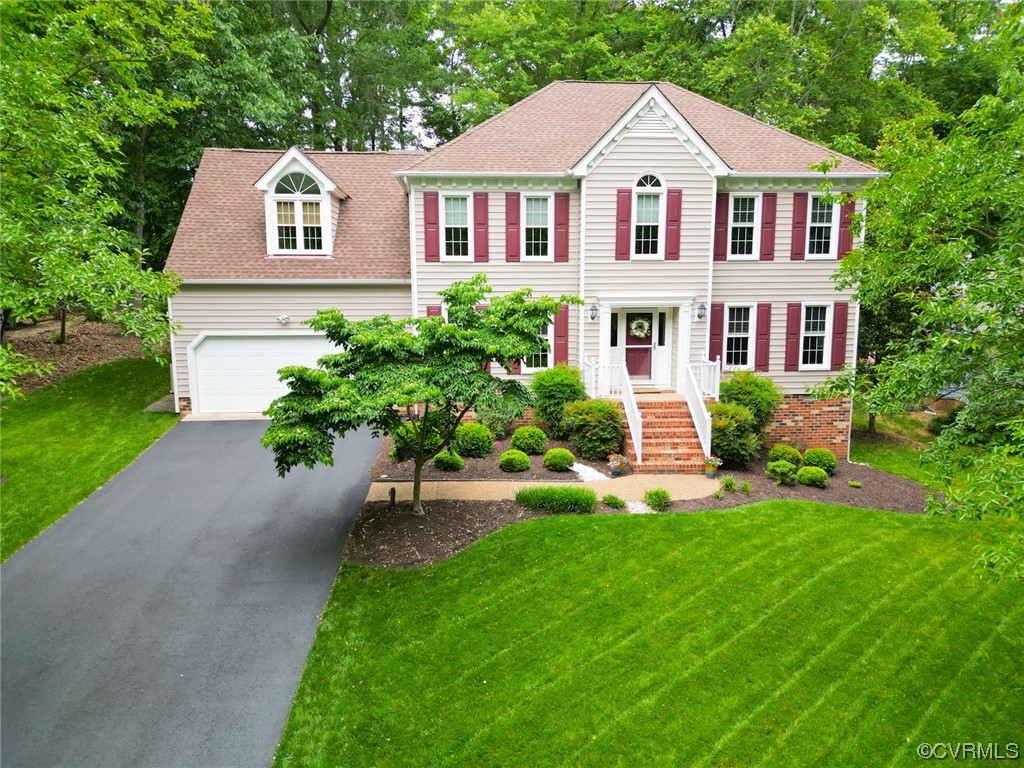 a front view of a house with a yard and trees