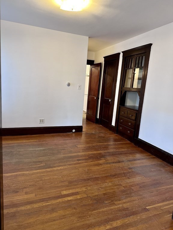 289 Highland Avenue, Unit 1L Quincy, MA 02170 - Photo 3 of 5 a view of an empty room with wooden floor and a window