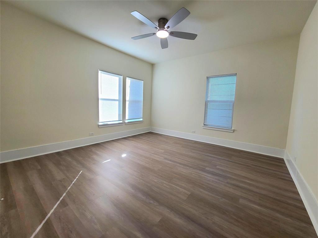 110 West Morton Street Denison, TX 75021 - Photo 14 of 15 an empty room with wooden floor and windows