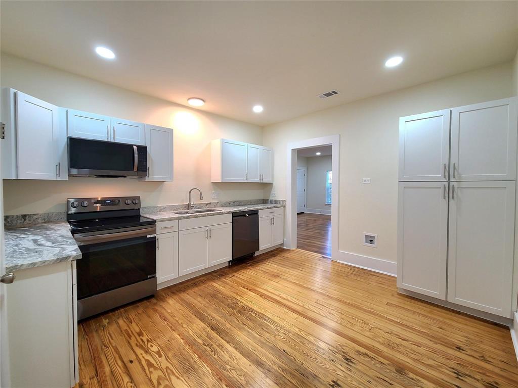 110 West Morton Street Denison, TX 75021 - Photo 6 of 15 a kitchen with a sink stainless steel appliances and white cabinets