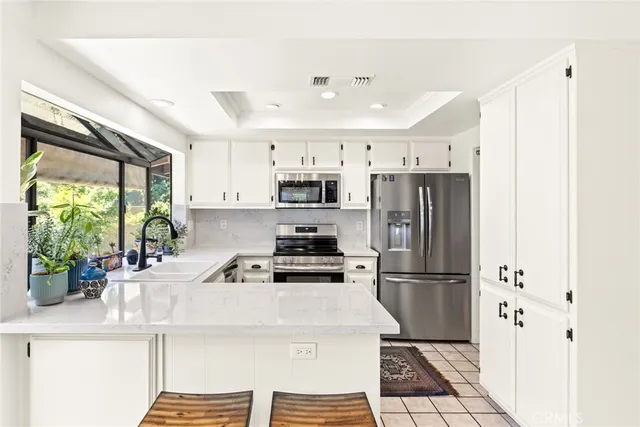 a kitchen with stainless steel appliances a refrigerator sink and stove