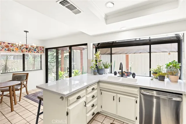a kitchen with sink cabinets and dining table chair