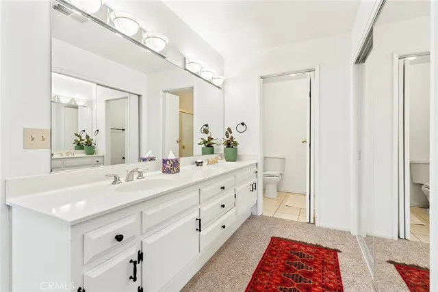 a spacious bathroom with double vanity and a mirror
